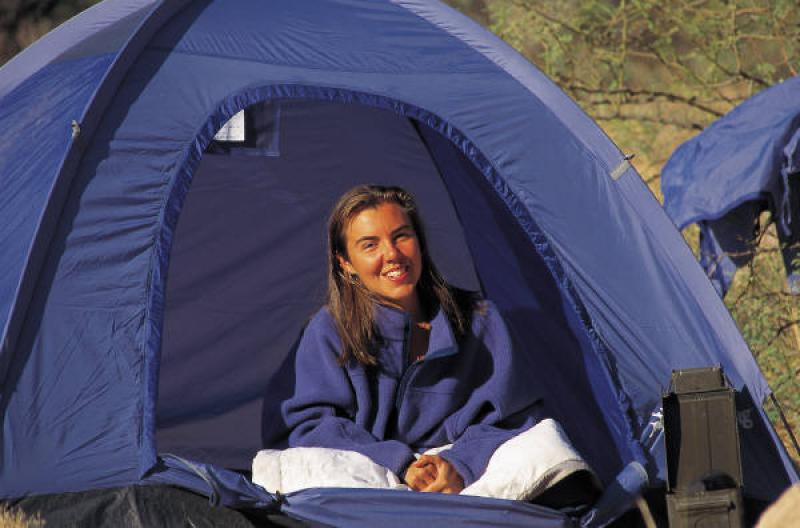 A person sitting inside a 2 person dome tent color blue